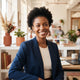 A diverse, smiling entrepreneur in a modern office, representing a satisfied customer.